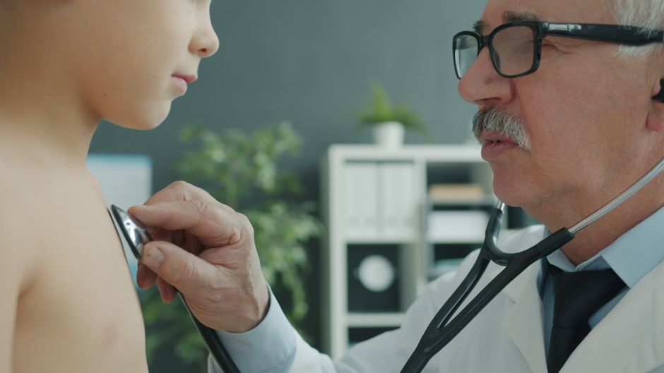 A pediatrician examining a child with a stethoscope